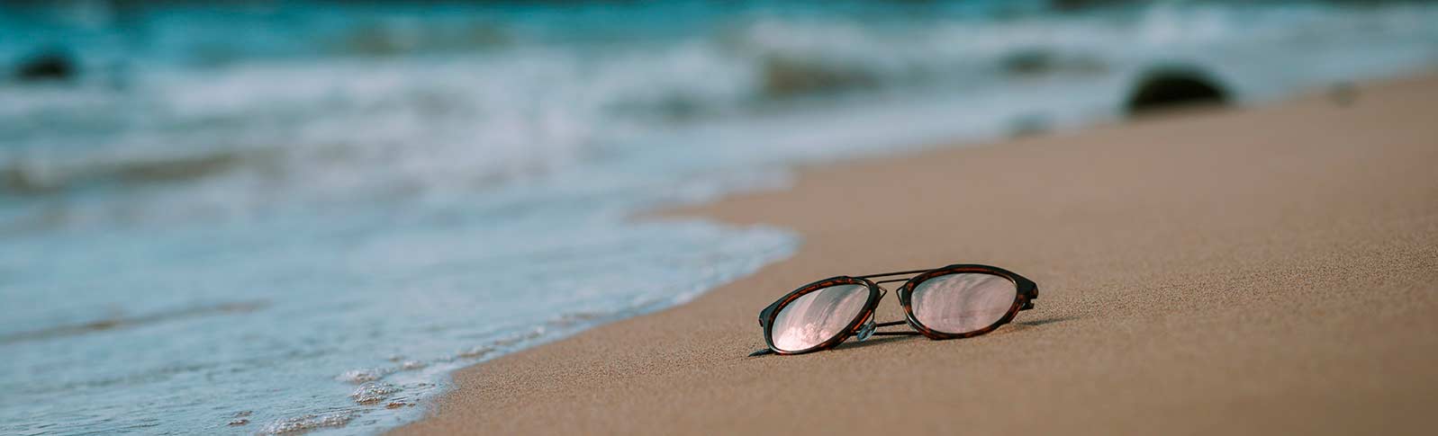 solbriller som ligger på en strand